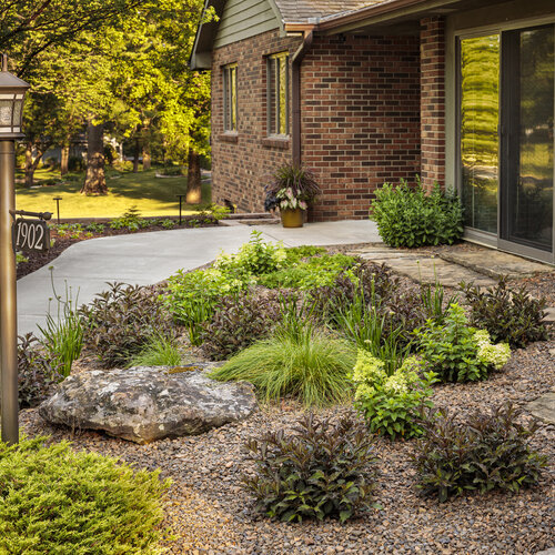 a small garden in front of a brick building